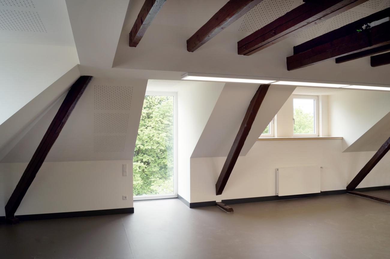 Durch vergrößerte Dachgauben und die freigelegte Dachkonstruktion entsteht ein lichter Seminarraum. Durch vergrößerte Dachgauben und die freigelegte Dachkonstruktion entsteht ein lichter Seminarraum.