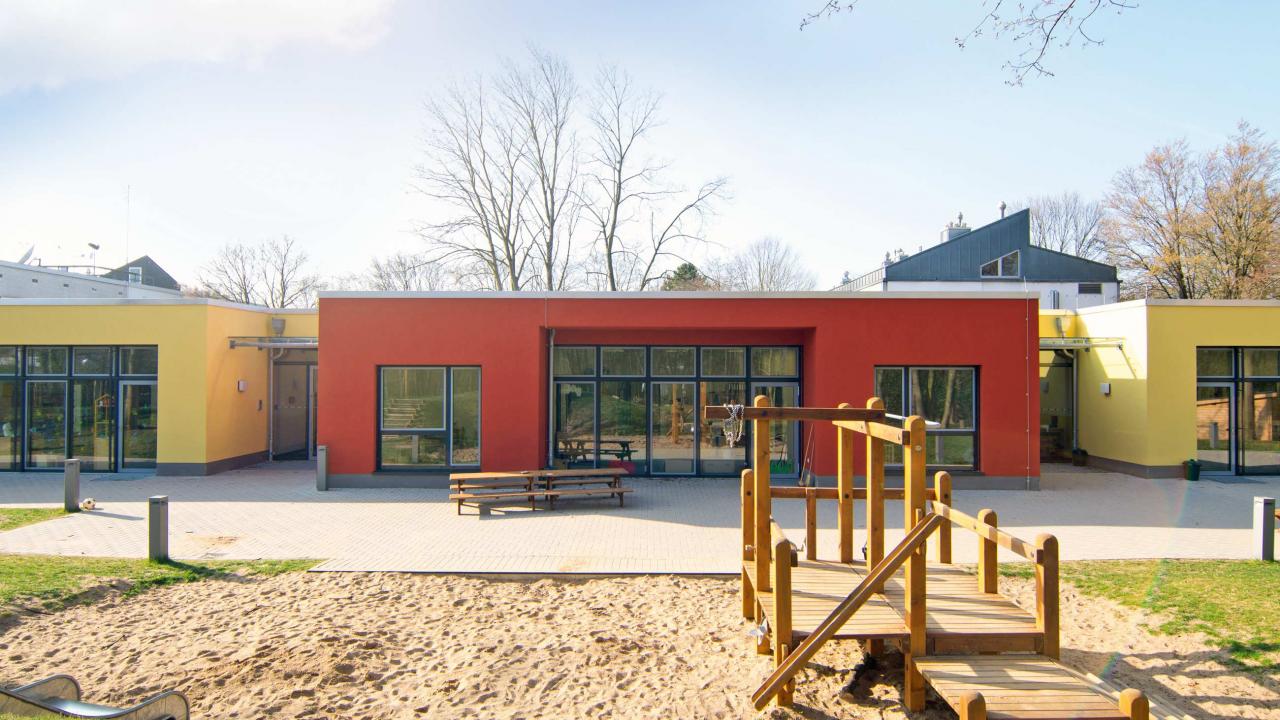 Generalplanung Neubau Kita in Bonn Spielplatz vor bunter Fassade